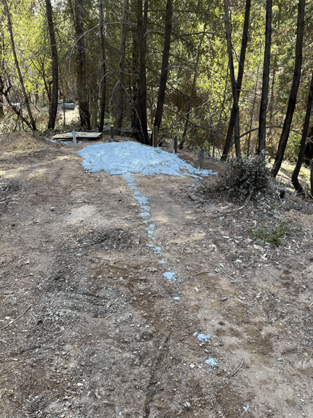 Sloppy pile of concrete, with some girders poking out of the ground.